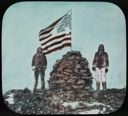 Image of Two Inughuit Men at Cape Columbia Cairn with U.S. Flag